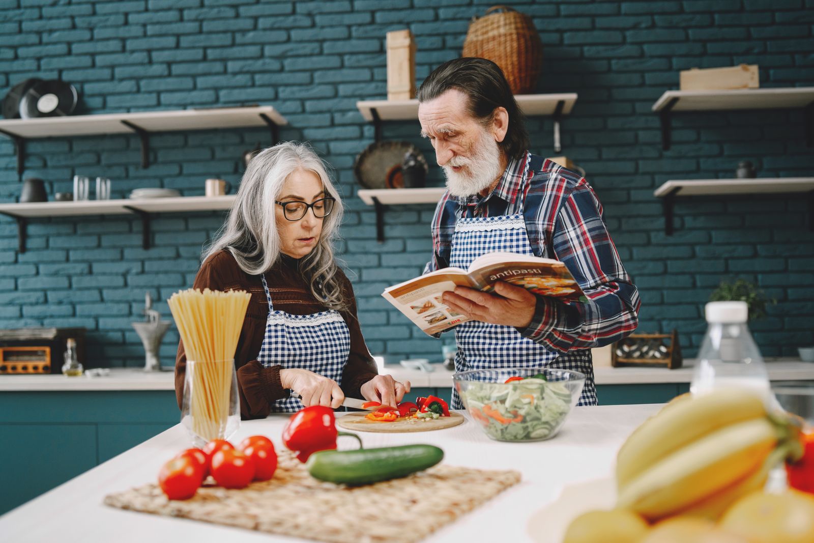 An older couple preparing a meal together in the kitchen