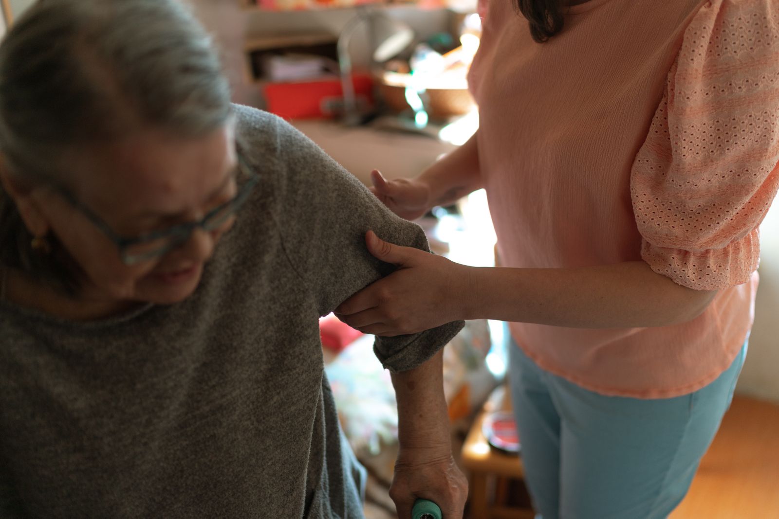 A caregiver helping an older woman move safely through her home